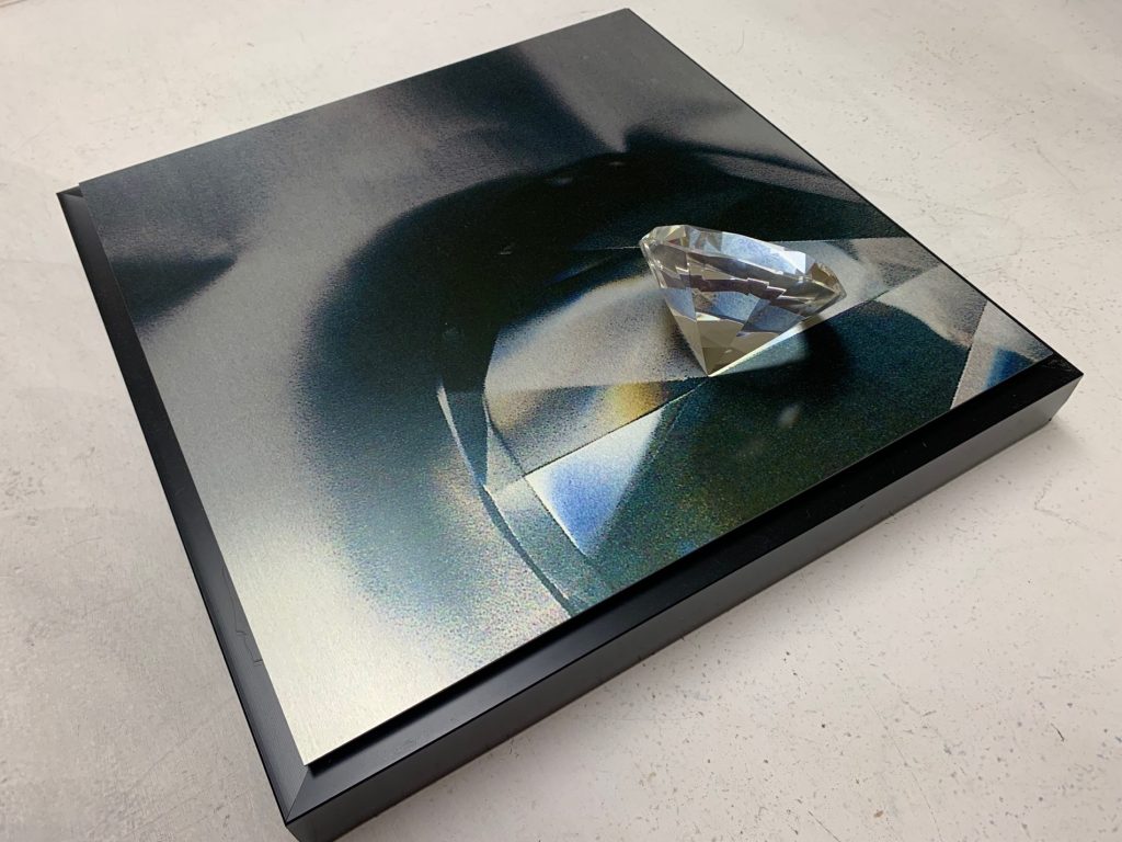 Connie Zehr&nbsp;• <em>Image and Object I</em>&nbsp;• Assemblage: metal print with small, round, gem-cut glass object&nbsp;• 12″×&nbsp;12″×&nbsp;2″&nbsp;• $50.00