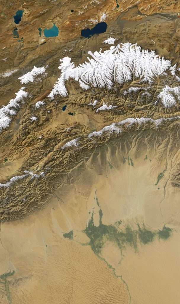 Jay Hart&nbsp;• <em>West Kunlun</em>&nbsp;• Inkjet print of Landsat imagery&nbsp;• 23″×&nbsp;40″&nbsp;• $500.00<div class="fb-text&quot><p style="margin-top:5px; text-align:center; font-size: 0.8em; ">The final section is sited in Asia, where our growing-huge populations are so dependent upon a system of water-borrowing; highlands are subsidizing massive communities in the adjacent lowlands via now-ever-more-erratic river flow. One surmises that very tall mountains are better as source areas for these systems, but often the more moderate terrain yields better results. Using area above 20000 feet in the case of Kunlun, the ice-covered cluster straddling 81° east, called Kunlun Goddess Range, is 4 times larger than the area around Everest, and 12 times the size of source areas near to the Kali Gandaki gorge in central Nepal. All of them are paltry compared to the storages of high latitude.</p></div>